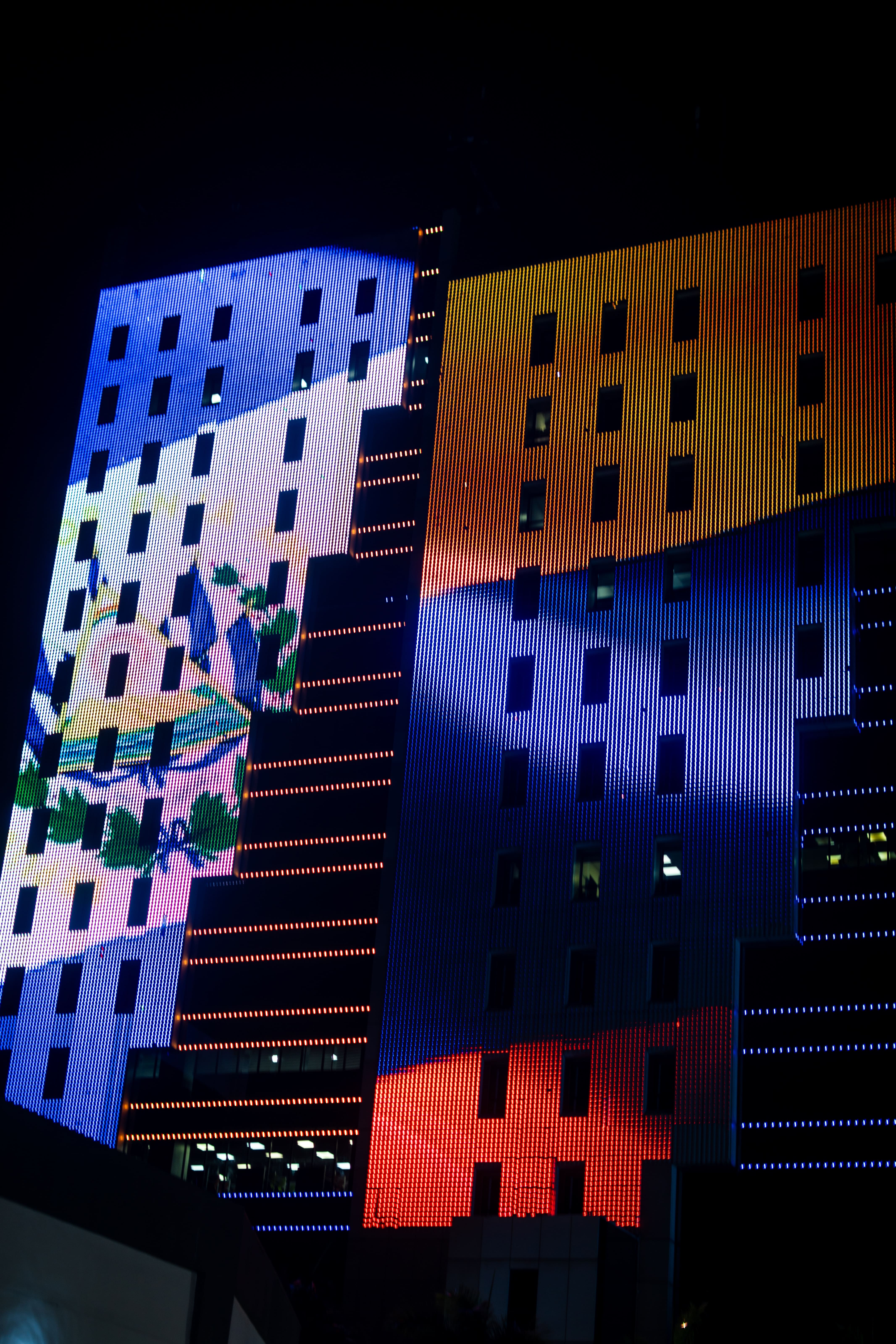 Las torres del Centro Financiero Gigante, iluminadas con las banderas de Colombia y El Salvador