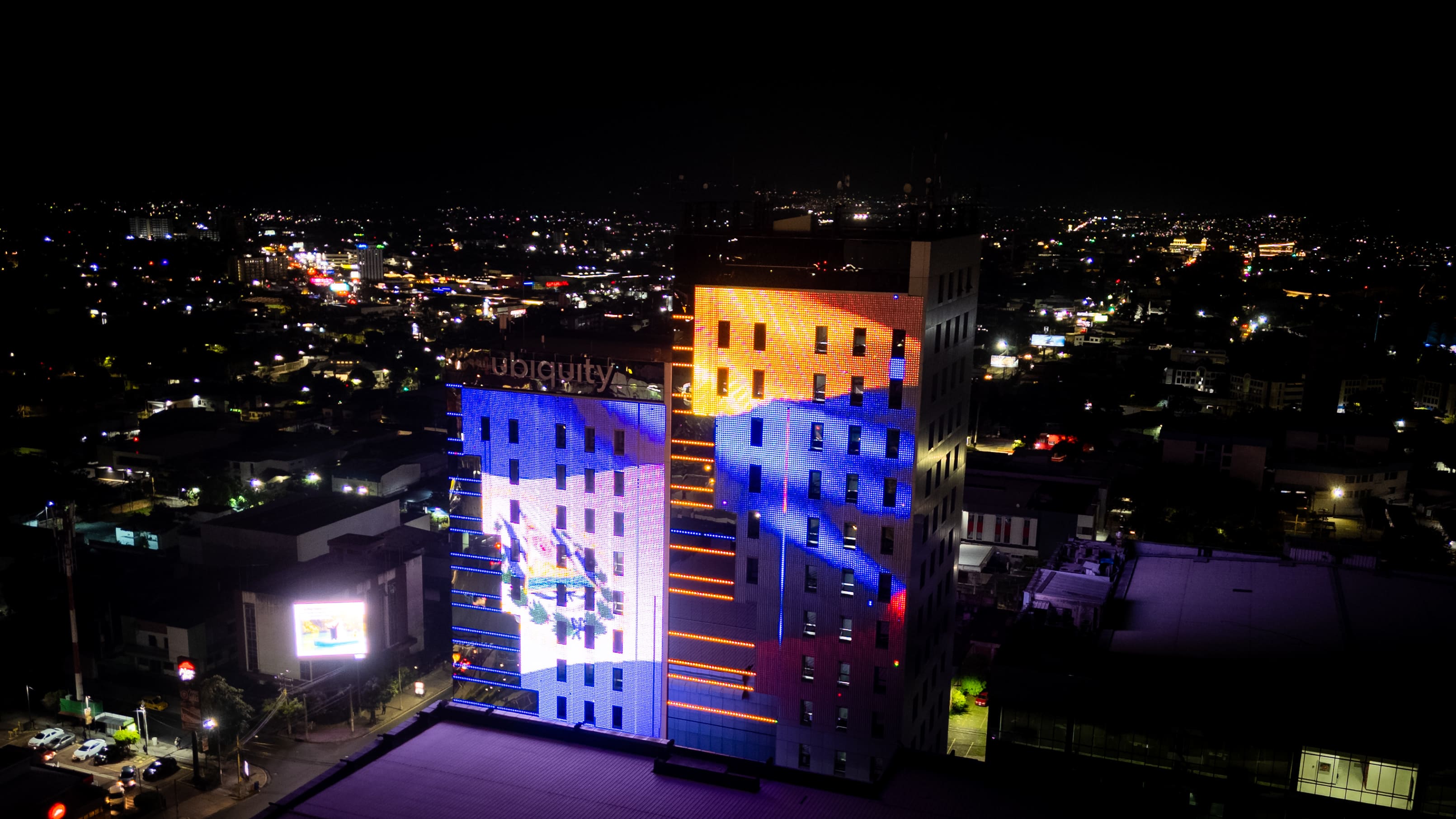 Las torres del Centro Financiero Gigante, iluminadas con las banderas de Colombia y El Salvador