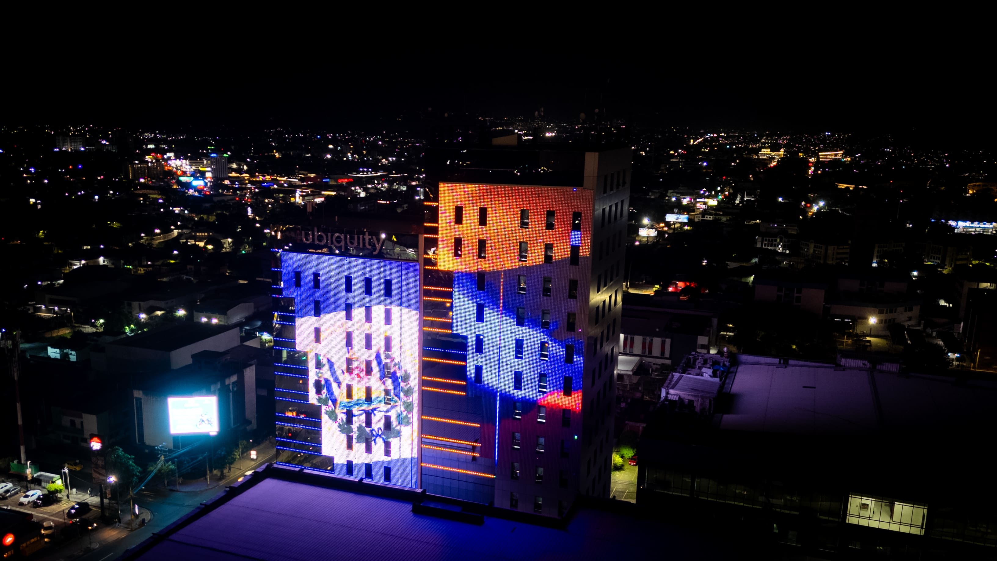 Las torres del Centro Financiero Gigante, iluminadas con las banderas de Colombia y El Salvador