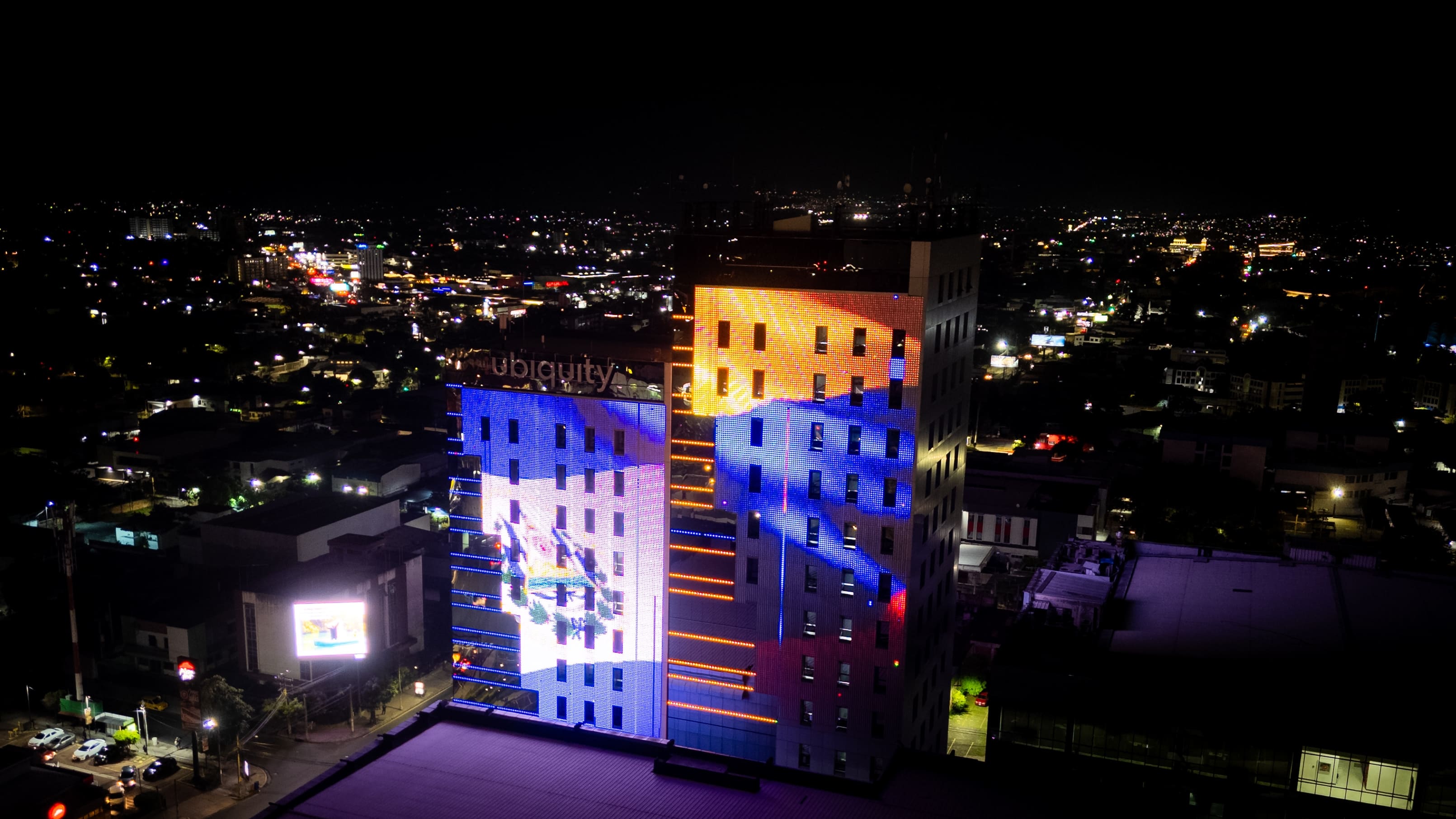 Las torres del Centro Financiero Gigante, iluminadas con las banderas de Colombia y El Salvador